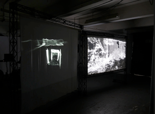 Black and white image of two works projected onto screens