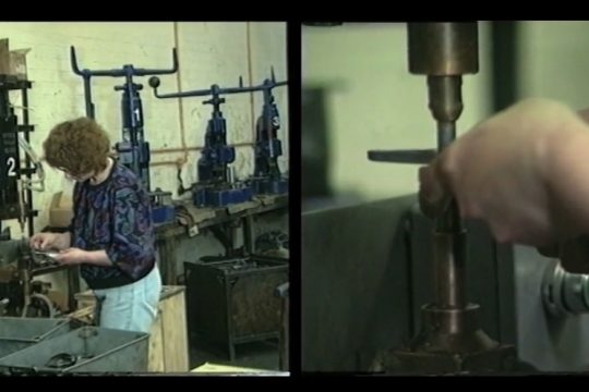 Still of archival footage of a female factory worker with a close-up shot of hands using heavy machinery and a wider shot of her using macinery
