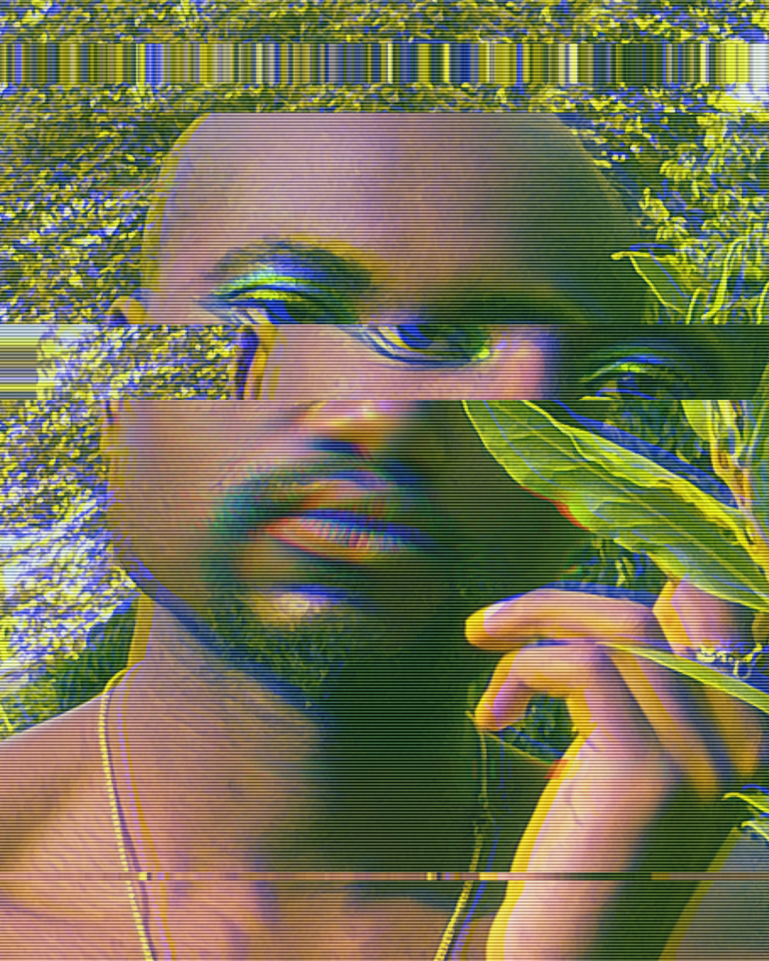 Close up image of Samiir's face, distorted by a section of his upper profile offset. His hand is touching a green leaf.