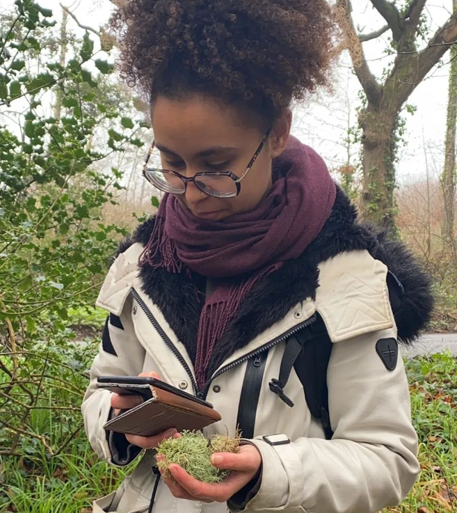 Charlotte outdoors holding a lichen ball