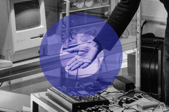 Black and white image of Gary's hand gesturing towards technical equipment